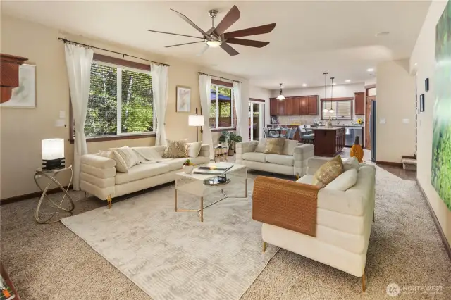 Light-filled, this oversized living room features a cozy gas fireplace and soaring ceilings anchored by two tall picture windows that frame serene views of the private yard and lush greenbelt. A perfect space for gatherings or quiet moments at home