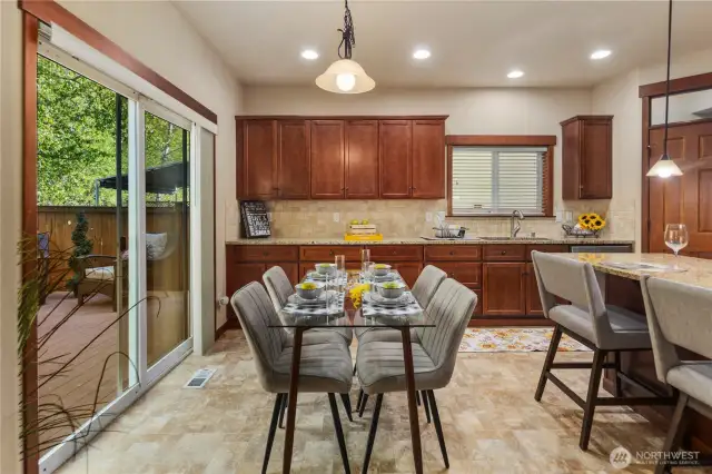 The dining area sits just off the kitchen island and opens to the patio through sliding glass doors—ideal for hosting and indoor-outdoor enjoyment.
