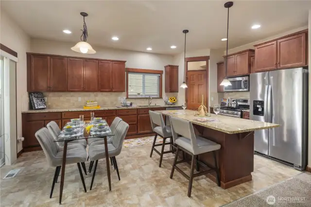The dining area sits just off the kitchen island and opens to the patio through sliding glass doors—ideal for hosting and indoor-outdoor enjoyment.