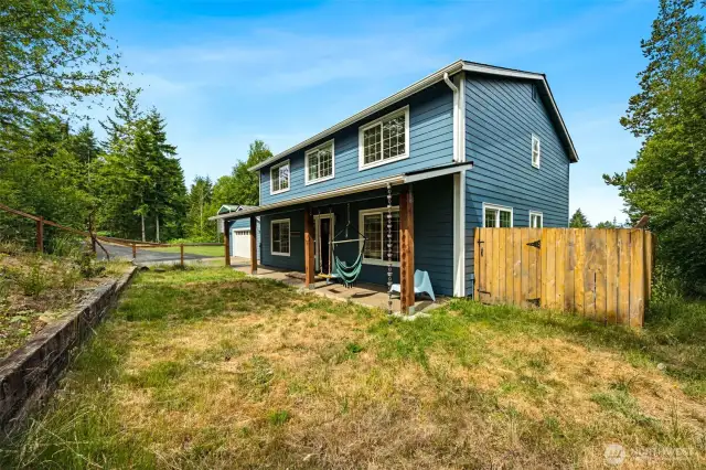 Front of home, fully fenced in front yard, covered RV parking to the left of attached garage