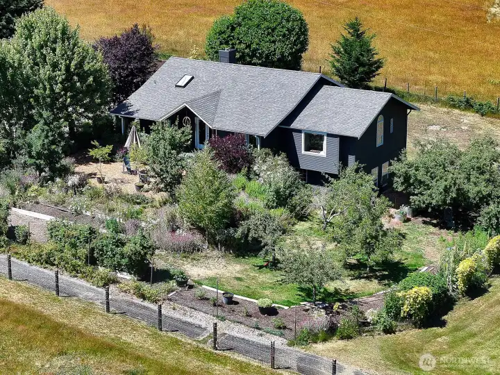 Fruit trees, berries, flowers and mature landscape create a private front yard. The yard is surrounded by pasture land providing a gorgeous territorial view and lots of light.