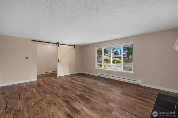 This bright living space showcases lots of natural light and a stylish barn door that adds charm while providing privacy when needed.