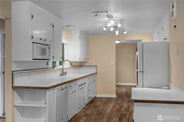 The kitchen boasts ample counter space and charming, character-filled cabinets