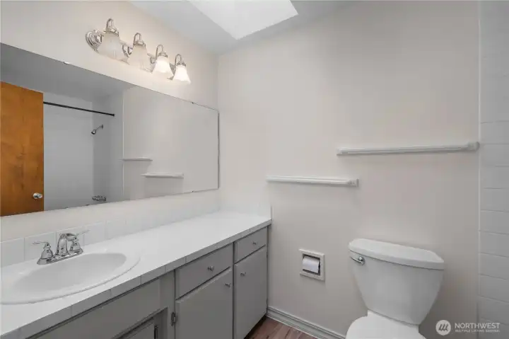 The bathroom is filled with natural light from a skylight and offers plenty of counter space and storage.