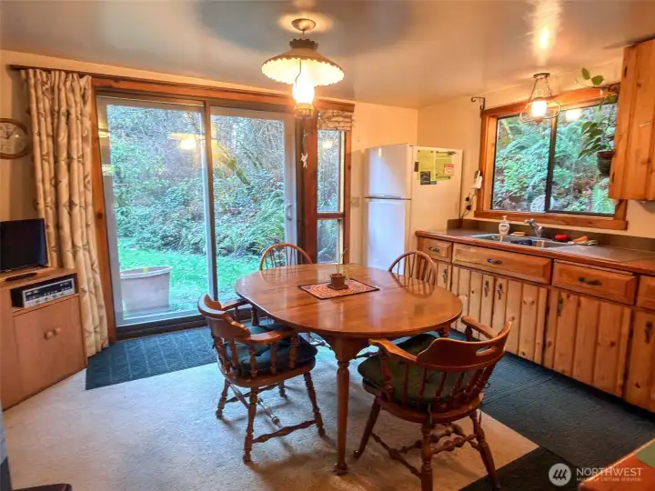 Entering back into the kitchen from the pantry to enjoy the beautiful greenery through the sliding glass door and window over the kitchen sink.