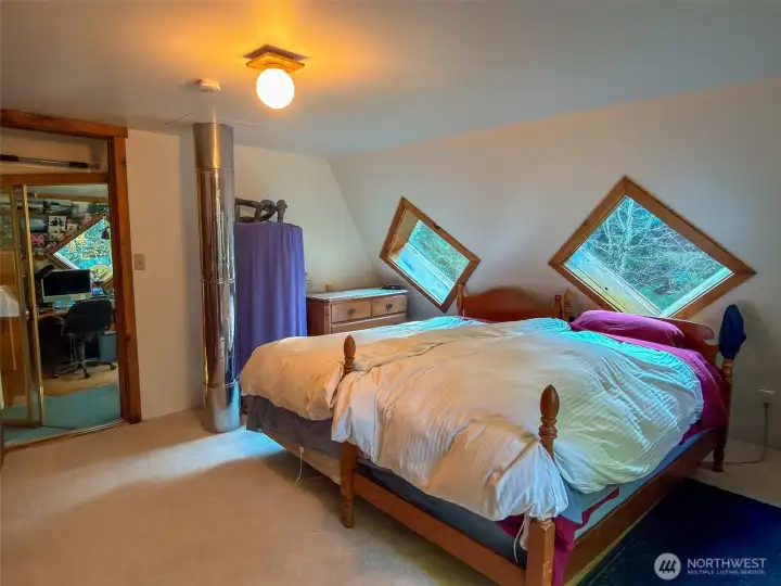 Upper bedroom with electric hot water heater and doorway to the office loft.
