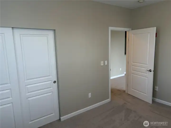 Spacious bedroom with plush carpeting and dual closets for added storage and comfort.