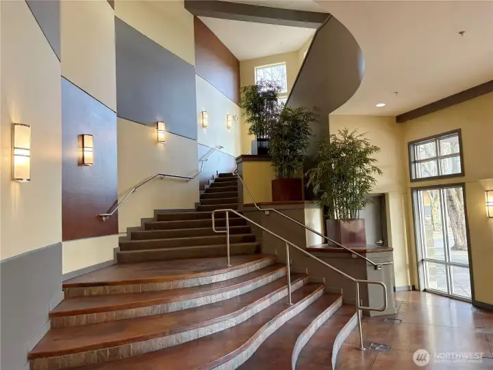 Grand lobby staircase featuring architectural detail and a refined residential entrance experience.