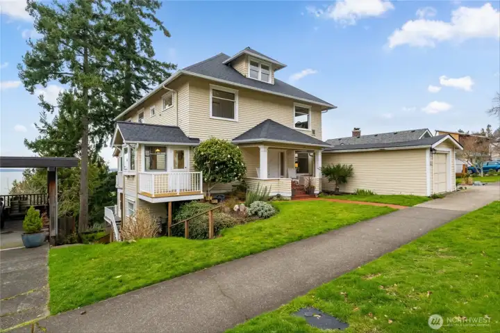 Timeless American Foursquare architecture with welcoming covered porch and mature landscaping.