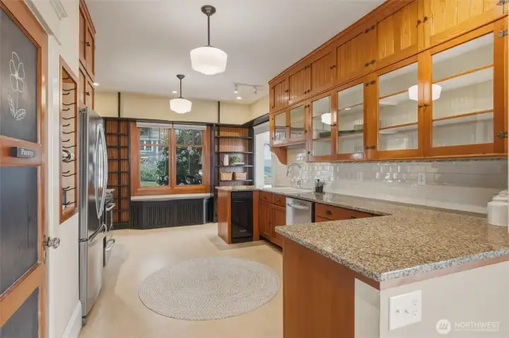 Generous kitchen with extensive cabinetry, built-in shelving, and abundant natural light