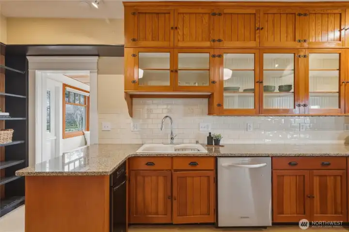 Granite counters, custom cabinetry, and subway tile backsplash create a warm, functional kitchen