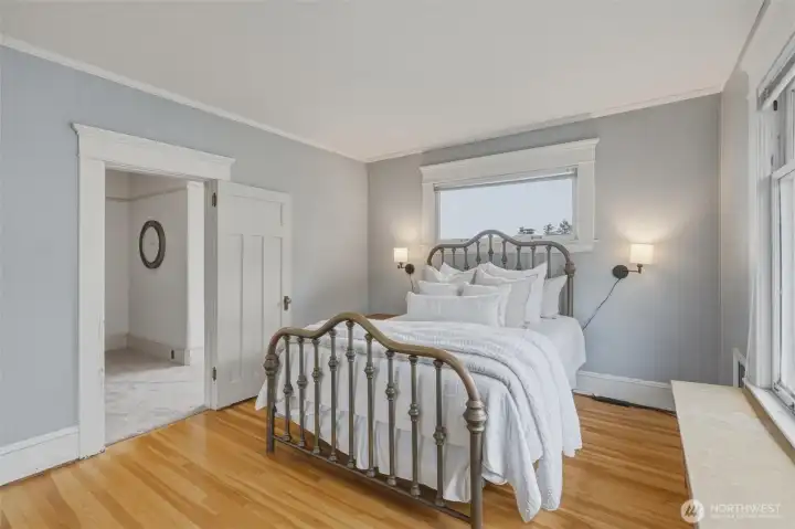 Comfortable second-floor bedroom with generous natural light and nearby bath