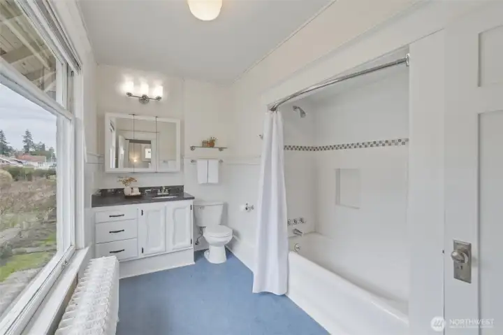 Spacious second-floor bath with tub/shower, vanity storage, and natural light