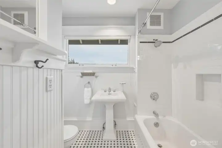 Second-level guest bath with classic subway tile, pedestal sink, and hex tile flooring