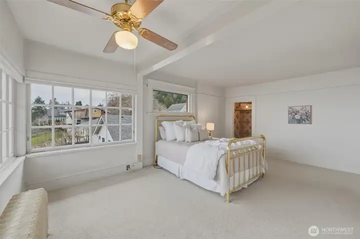 Light-filled bedroom with dramatic wall of windows and breathtaking Bellingham Bay views.