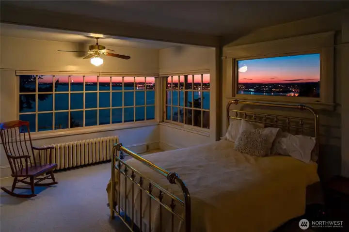 Spacious bedroom opening to a stunning wall of windows showcasing sweeping Bellingham Bay views