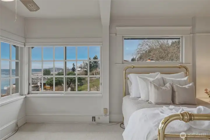 Spacious bedroom opening to a stunning wall of windows showcasing sweeping Bellingham Bay views.