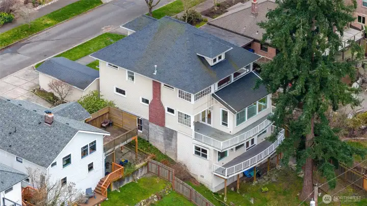 Drone view showcasing the home’s multi-level decks, sunroom, and terraced backyard