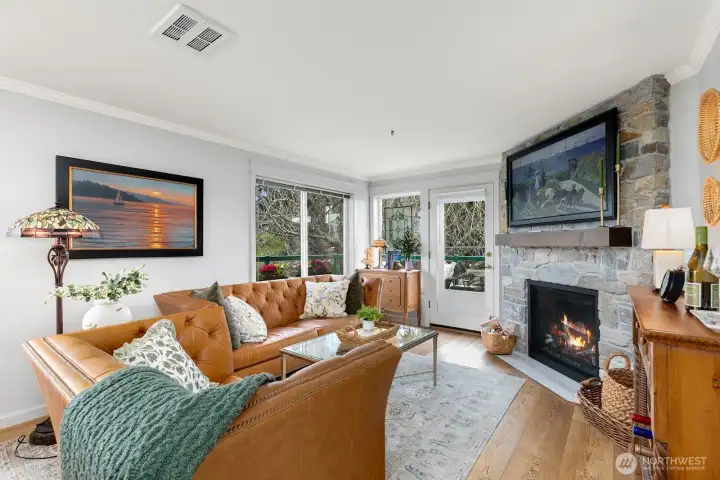 Bright Living Room with stone facade and custom fireplace mantle.  Gas fireplace and large SE-facing windows overlooking your wrap-around deck.