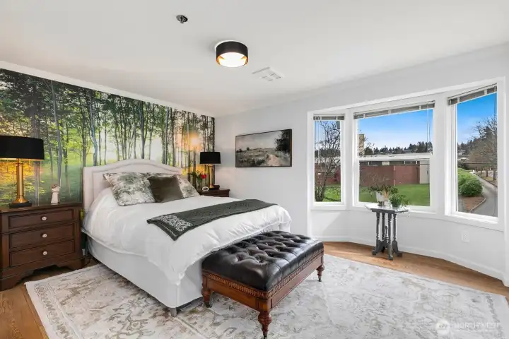 Primary bedroom with bump-out bay window and custom NW-inspired wallpaper mural.