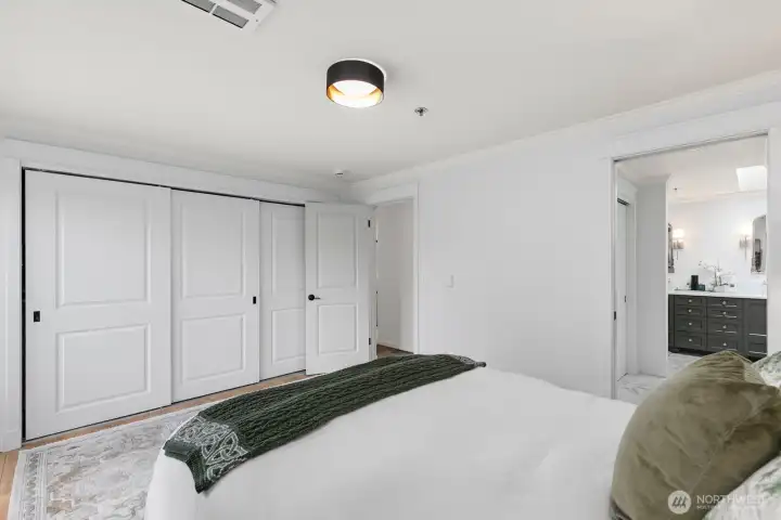 3-door closet in primary bedroom and closet designed by California Closets.  Additional 2-door closet in pass-through to bathroom.