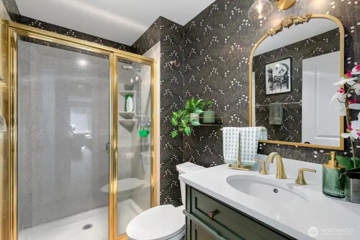 Second bathroom with shower, sink and toilet - discretely accessed in the hallway.
