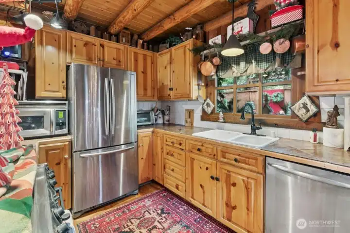 Kitchen with stainless steel appliances and original wood flooring.