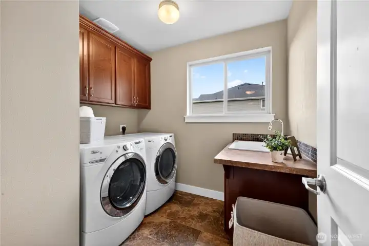 Utility room is conveniently located on the second floor and features extra cabinet storage and a utility sink for added functionality.