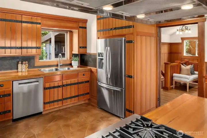 A Viking gas range is flanked by other stainless appliances and an abundance of storage and counter space. A Viking gas range is flanked by other stainless appliances and an abundance of storage and counter space.