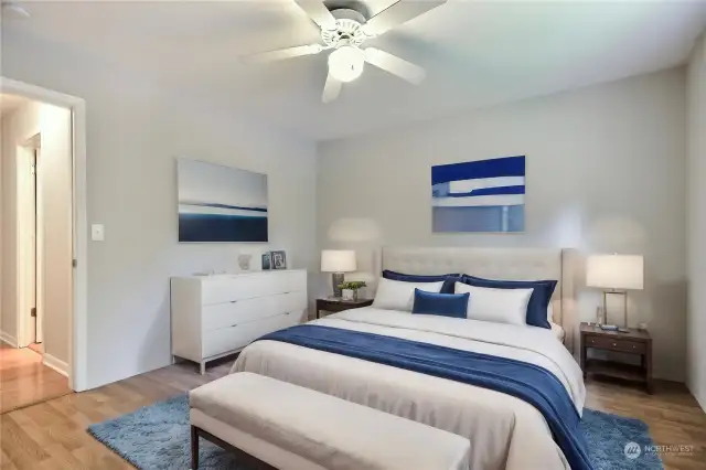 Primary bedroom, nice size, convenient ceiling fan, virtually staged.