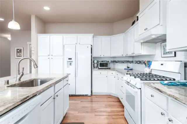 The clean, bright, and well-designed kitchen provides abundant storage and counter space.