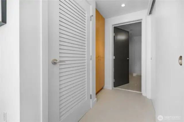 Hall way with closets to primary bathroom