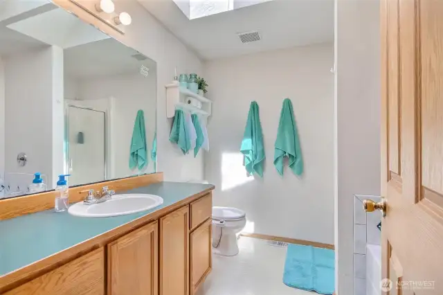 The primary bathroom is light, bright and features a walk-in shower and jetted, soaking tub.