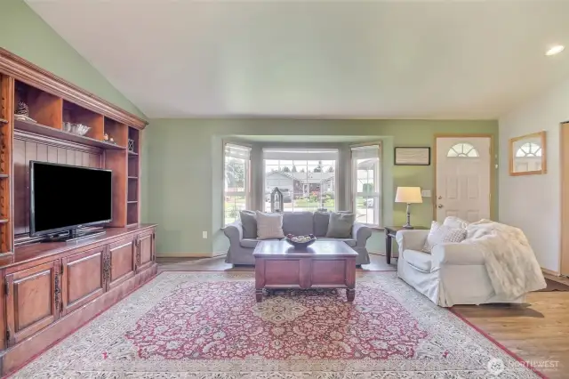 The spacious living room features a bay window