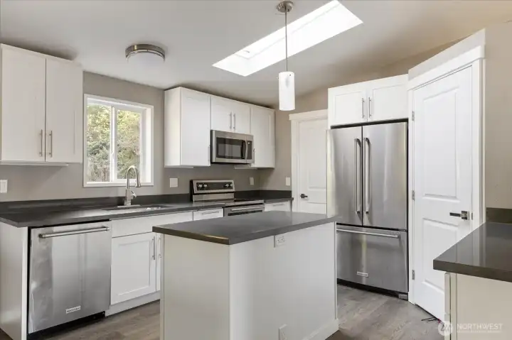 Bright kitchen featuring stainless steel appliances and quartz countertops.