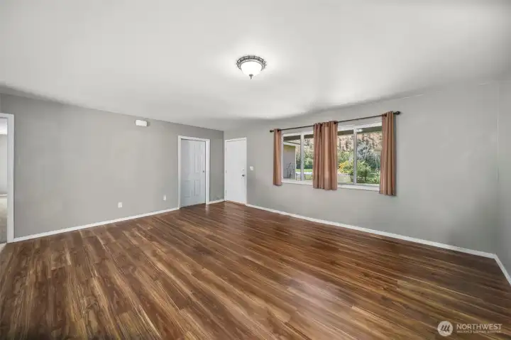 Living room with front entrance, door to the garage, and door to the primary bedroom is to the far left.