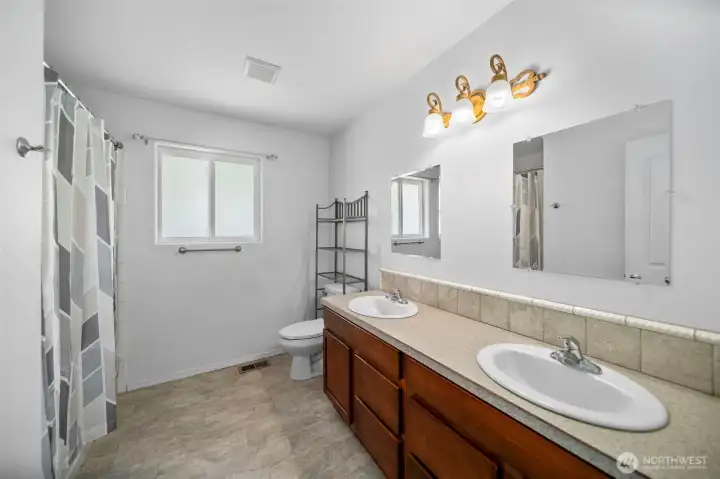Double sinks/vanities in primary bathroom. This is a full bath with both shower and tub.
