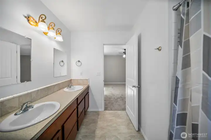 Primary bathroom looking towards primary bedroom. Shower/tub to the right.