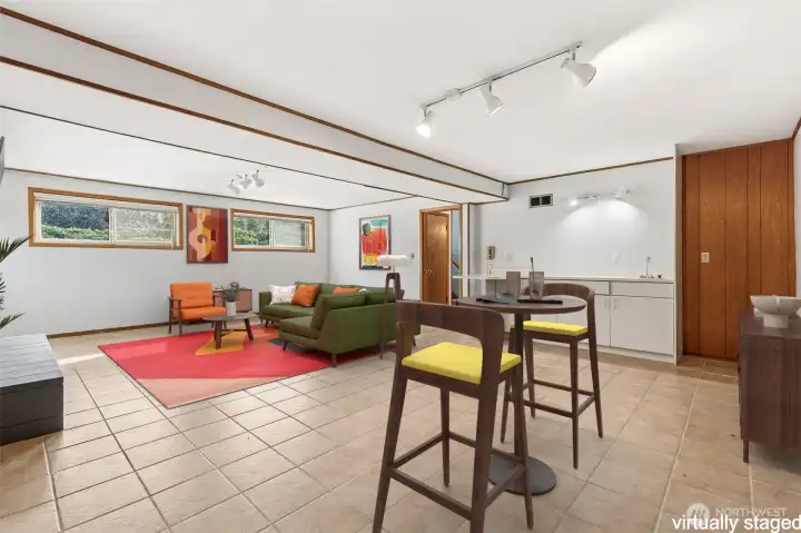 Virtually staged lower-level rec room showing wet bar that could easily become a kitchette, making this a great option for guests or adu.