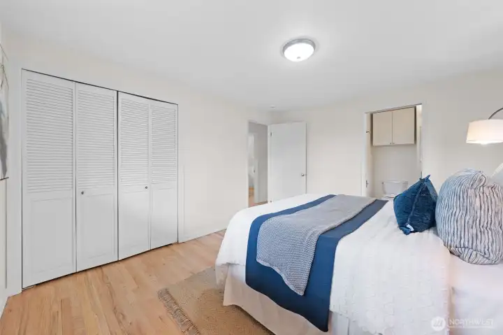 Alternate view of the primary suite featuring dual closets and direct access to the en-suite bath. Clean layout with generous wall space allows for easy furniture placement and everyday functionality.