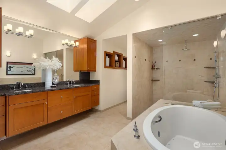The primary bathroom lives as a spa experience unto itself, with a double-sized walk-in shower, soaking tub, and skylights that create a serene, light-filled retreat.