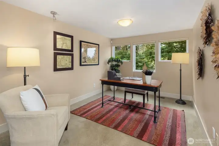 The loft-like office is spacious and filled with natural light, overlooking the backyard—a versatile and inspiring space that could easily serve as a library, den, or playroom.