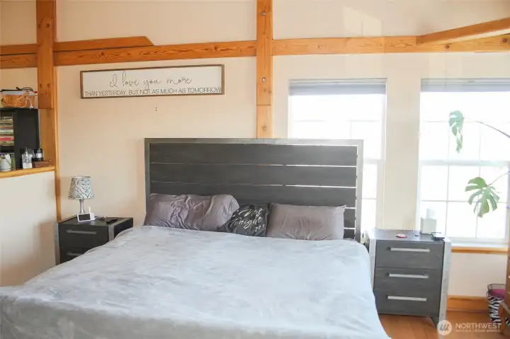 Comfortable primary bedroom with vaulted ceilings and natural light.