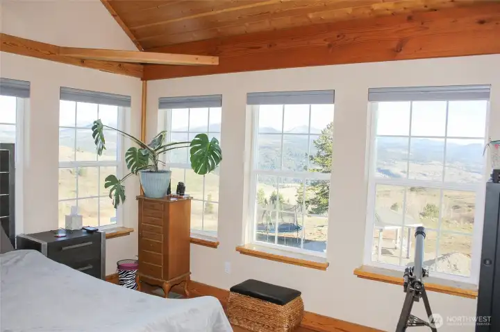 Rows of windows in the primary bedroom offer serene views.