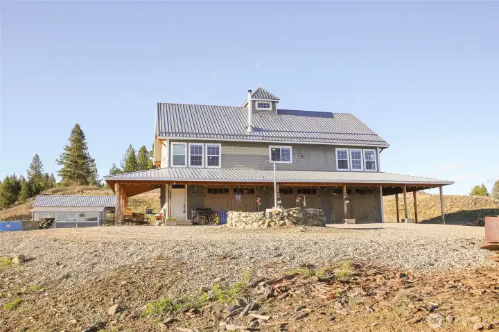 Exterior view highlighting the home, garage with shop, and detached structure.