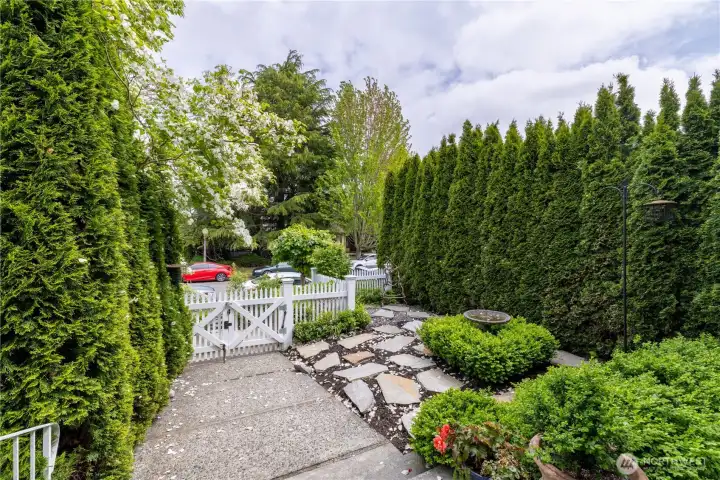 View from the porch of the easy maintenance, and semi-secluded front yard, elevated from this quiet street by an enclosing picket fence and gate.