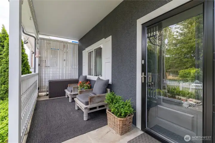 shady and cozy front porch has lovely view high above the shady street. Home entrance with a newer high-end glass and iron storm/ security door protecting the traditional 3/4 privacy glass inner door.