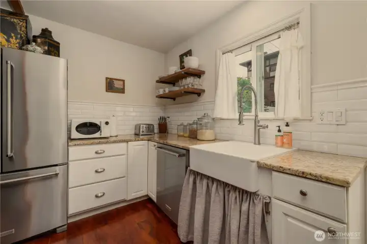 Beautiful vintage-style apron sink, ceramic tiled backsplash, granite counters and sunny window over-looking the back yard.