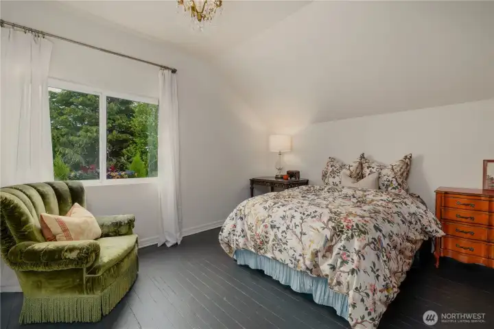 Large front bedroom with wonderful view window, charming painted wood floors, vintage lighting and gabled ceiling.