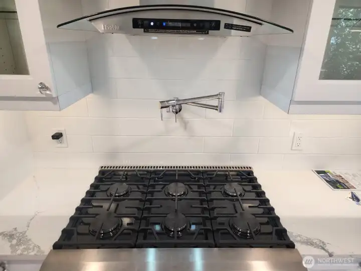Six burner propane stove with water faucet.